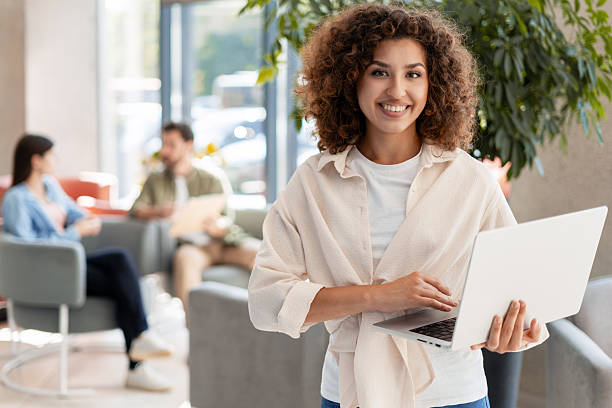 istock Young businesswoman smiling and using laptop in modern office 2232180139