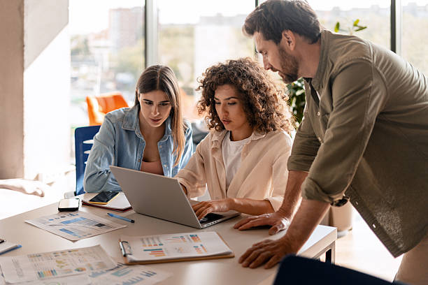 istock Focused colleagues working together on a laptop in modern office 2232180704