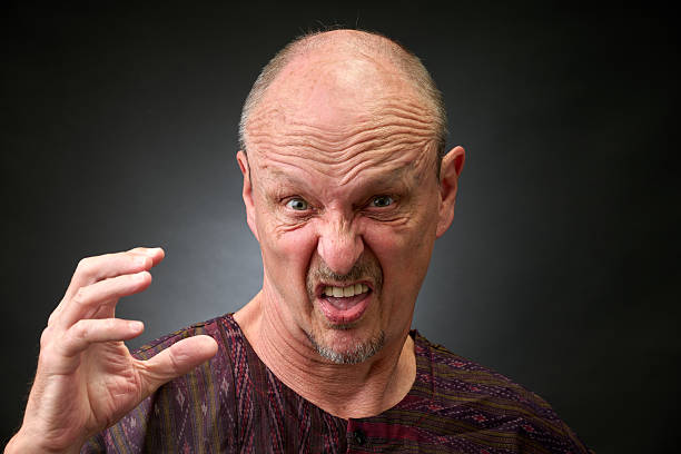 Closeup portrait of a senior man making funny faces in a vintage Harcourt style lighting