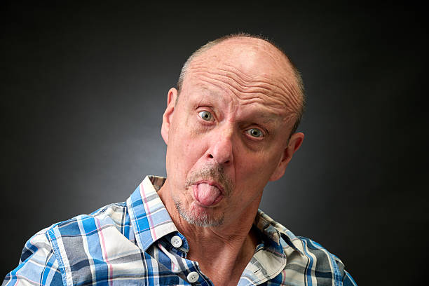 Closeup portrait of a senior man making funny faces in a vintage Harcourt style lighting