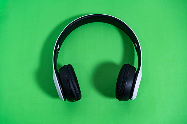 istock Wireless headphones lying on vibrant green background 2232181523