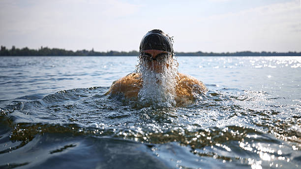 istock Senior swimmer emerging from water with intense strength 2232181676