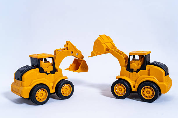 istock Two yellow toy excavators facing each other on white background 2232181704