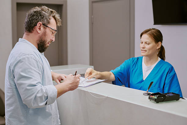 istock Middle Aged Caucasian Man Signing Document While Female Nurse Assisting 2232183172