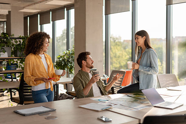 istock Business team enjoying coffee break, discussing work in modern office 2232183786