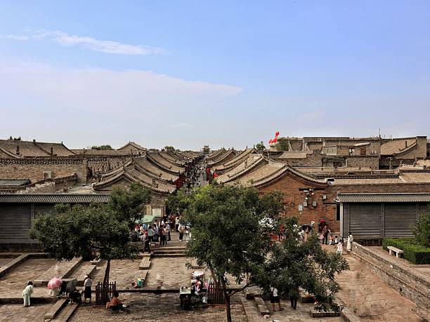 Step back into the Qing Dynasty within the formidable walls of ancient Pingyao. This captivating image captures the soul of a city untouched by time: a labyrinth of cobbled lanes, ornate traditional courtyards, and majestic gates. Since \