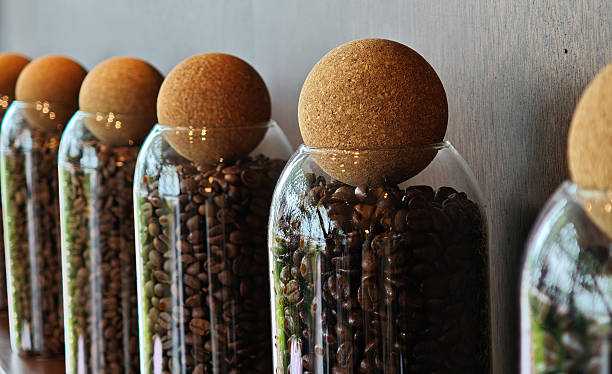 Close up coffee beans in glass jar on coffee shop counter