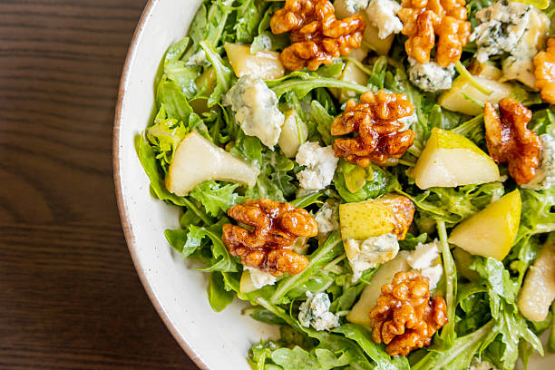 healthy fall salad with arugula pear cheese and candied walnuts