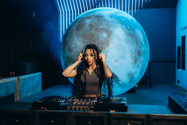 Female DJ Performing in Front of Large Illuminated Moon Backdrop