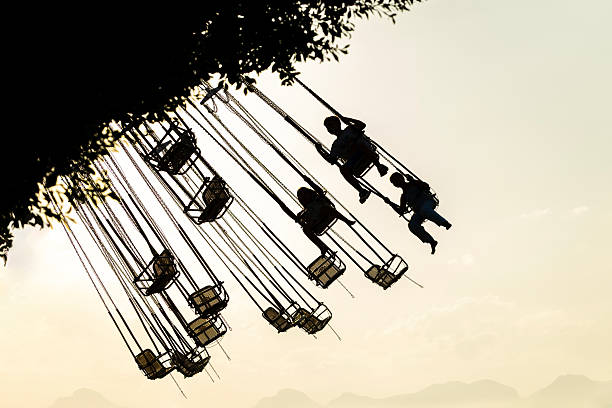 istock Little kids riding a spinning swing at an amusement park 2232187783