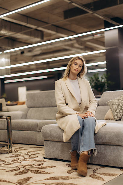 istock Woman Sitting Comfortably on Modern Grey Sofa in Contemporary Interior Design Setting 2232188335