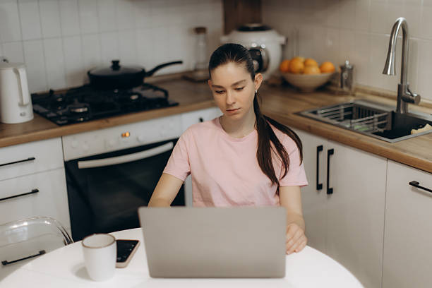 istock Young Woman Working on Laptop in Modern Kitchen Setting 2232188452