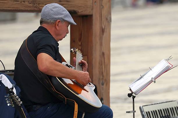 Portrait shot of young man playing guitar at seaside