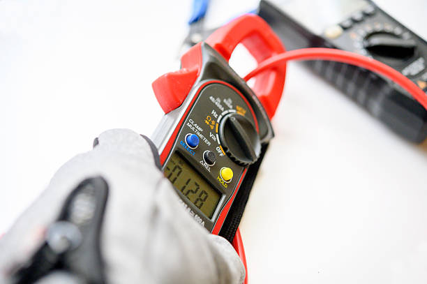 Workers use clamp meter to measure the current of electrical wires produced from solar energy for confirm to normal current