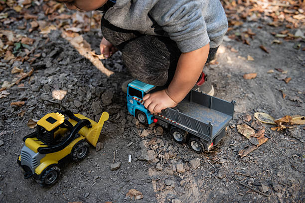 istock Child playing with toy trucks in dirt, embracing imagination and fun 2232191213