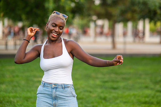 istock Young woman dancing in the park, enjoying summer day 2232192572