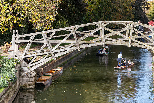 Cambridge, England. Wooden Mathematical Bridge of 1749 at Queens' College, designed by William Etheridge and built by James Essex, with a punt passing under on the River Cam