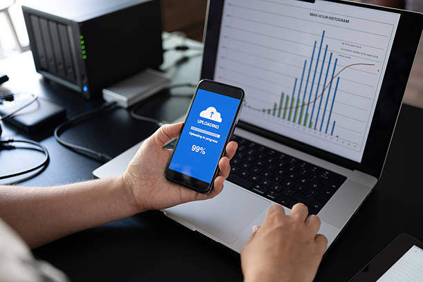 istock Woman uploading files to cloud using her smart phone 2232196504