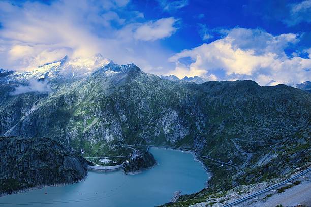 Stunning view of the Swiss Alps with a serene lake and dramatic clouds, capturing the beauty of nature.