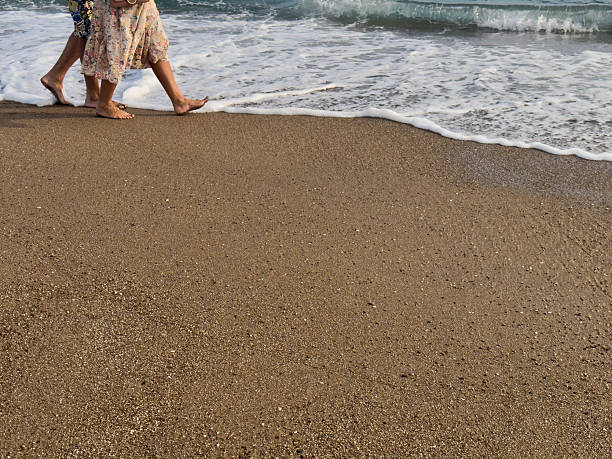 feet in wet sand and waves