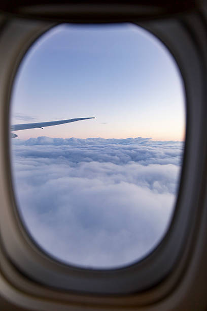 istock Airplane window frame soft pastel sky above fluffy clouds wing silhouette stretching horizon peaceful flight atmosphere 2232208721