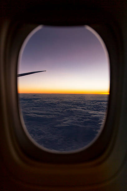 istock Sunset airplane window glowing orange horizon dense textured cloudscape wing tip silhouetted dramatic twilight sky 2232208722