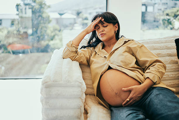 istock Pregnant Woman Resting on Cozy Couch with a Headache 2232209033