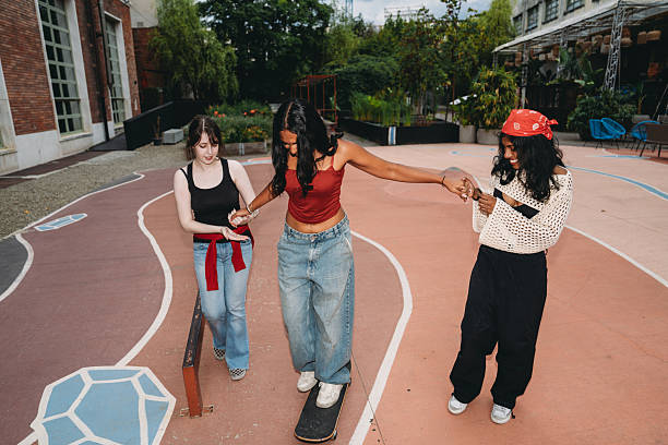 istock Young women helping friend balancing on skateboard 2232209790
