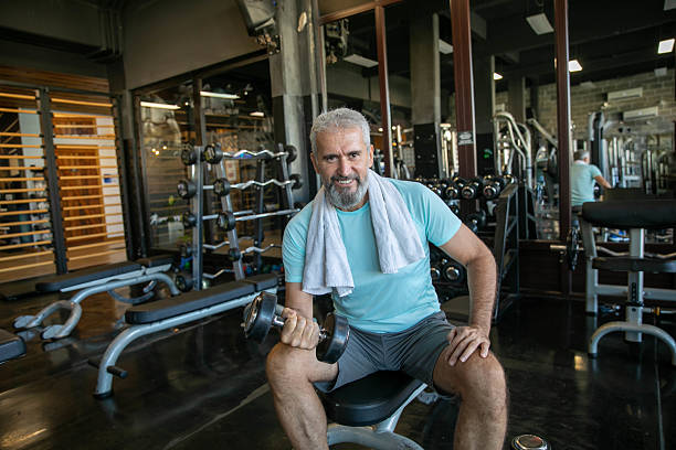istock Senior Man Exercising in a Modern Gym and Smiling During Workout 2232212757