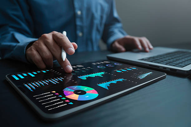 un analista utilizza un computer e una dashboard per l'analisi aziendale dei dati e il sistema di gestione dei dati con kpi e metriche collegati al database per la finanza tecnologica, le operazioni, le vendite, il marketing - dashboard supporto visivo foto e immagini stock