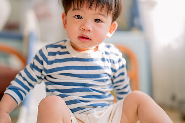 istock Happy Asian toddler boy laughs joyfully while playing on plastic slide toy, demonstrating gross motor development and emotional regulation through active play exploration and sensorimotor learning experiences 2232218173