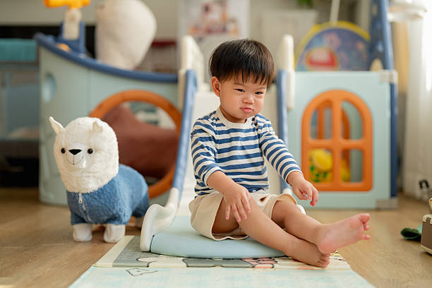 istock Happy Asian toddler boy laughs joyfully while playing on plastic slide toy, demonstrating gross motor development and emotional regulation through active play exploration and sensorimotor learning experiences 2232218179