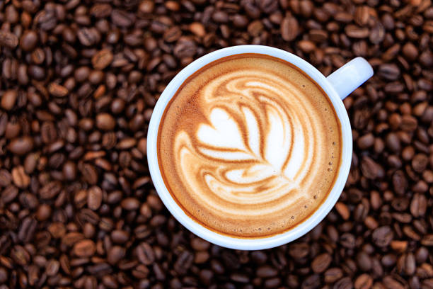cappuccino white cup and roasted coffee beans backgrounds abstrack, top view and copy space.