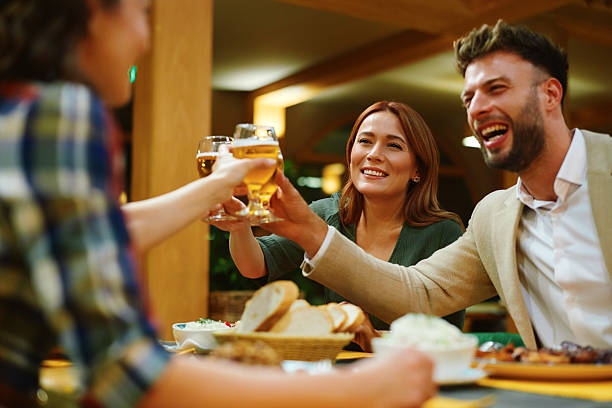 istock Happy friends toasting with beer glasses at restaurant dinner 2232227044