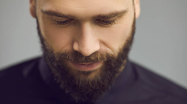 istock Studio close up portrait of handsome bearded man looking down with eyes half closed 2232229244