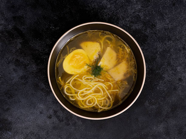 Enjoy a warm bowl of homemade chicken noodle soup with fresh herbs and soft boiled eggs, perfect for any occasion.
