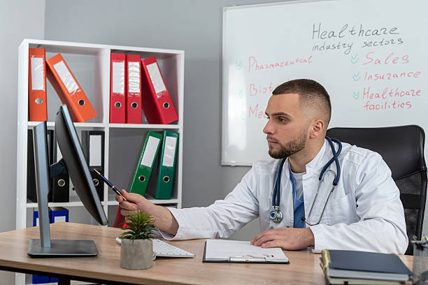 istock doctor man sitting at the desk using laptop computer for webinar training ar medical themes 2232230063