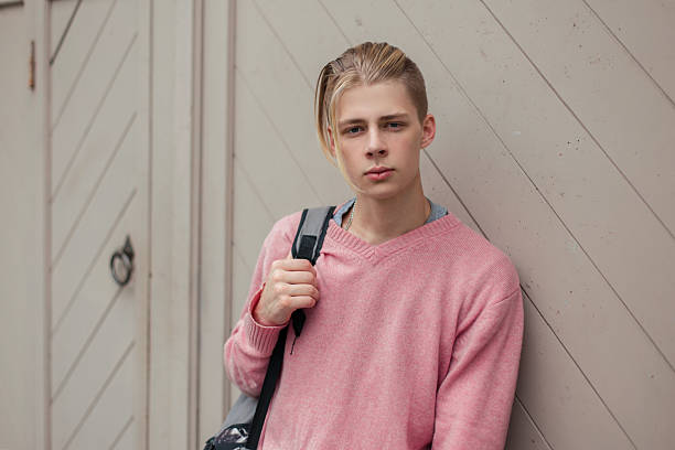 istock Handsome stylish young guy with a backpack near the wall 2232238520