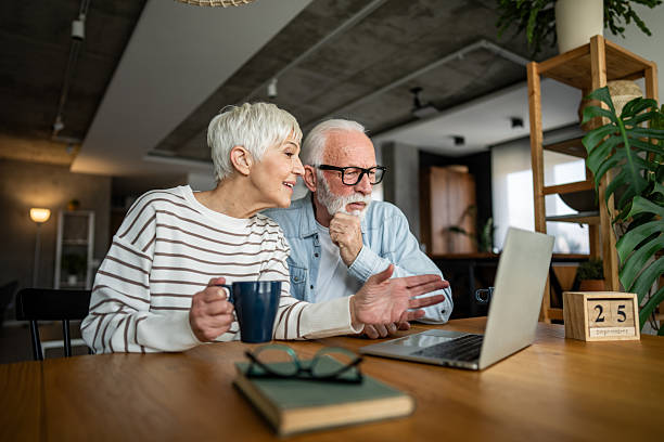 istock Senior couple using laptop at home, enjoying modern technology 2232239360