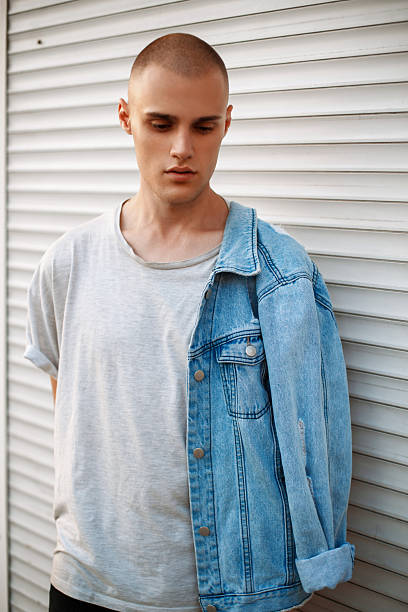 istock Stylish handsome man with a denim jacket near a metal shutter 2232239639