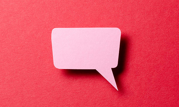 istock Pink cut out paper speech bubble with shadow and copy space for text on red background, close-up flat lay top view conceptual backdrop 2232240376
