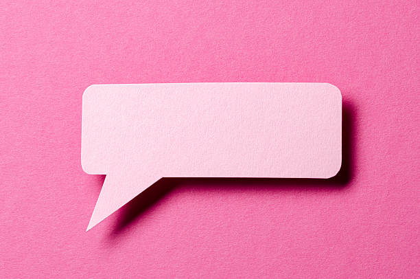 Paper speech bubble with shadow and copy space for text on pink background, close-up flat lay top view conceptual backdrop