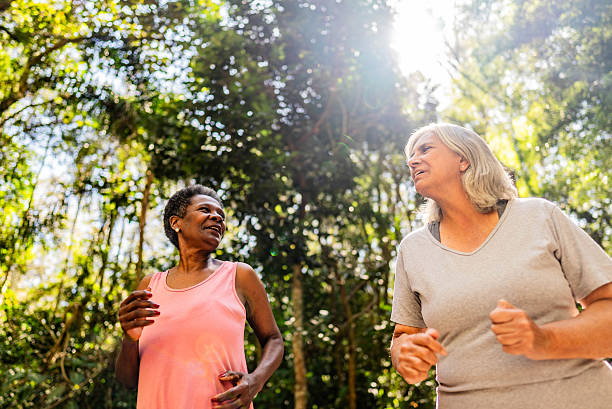 istock Senior friends talking and doing jogging on the public park 2232241833