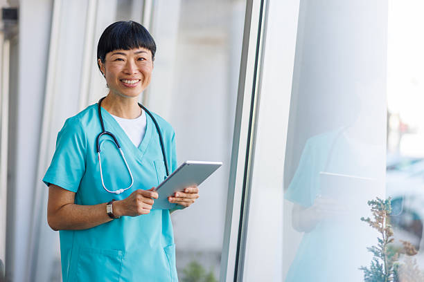 istock Smiling doctor using digital tablet in hospital corridor 2232241981