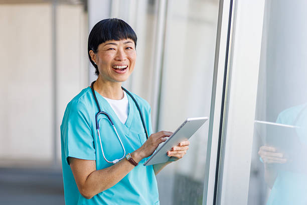 istock Happy doctor smiling and using digital tablet in hospital corridor 2232242002