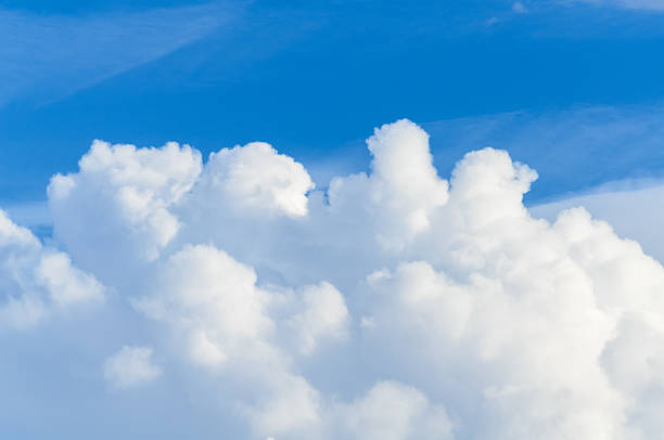 White soft fluffy sunlit cumulus clouds and blue sky on a sunny day