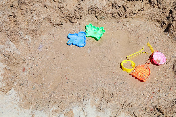 Colorful beach toys on sandy surface.