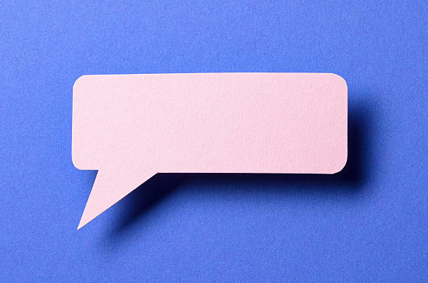 istock Pink cut out paper speech bubble with shadow and copy space for text on blue background, close-up flat lay top view conceptual backdrop 2232244593