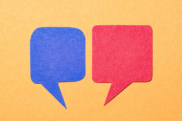 istock Blue red blank cut out paper speech bubbles with copy space for text on orange background, flat lay top view conceptual conversation backdrop 2232244770
