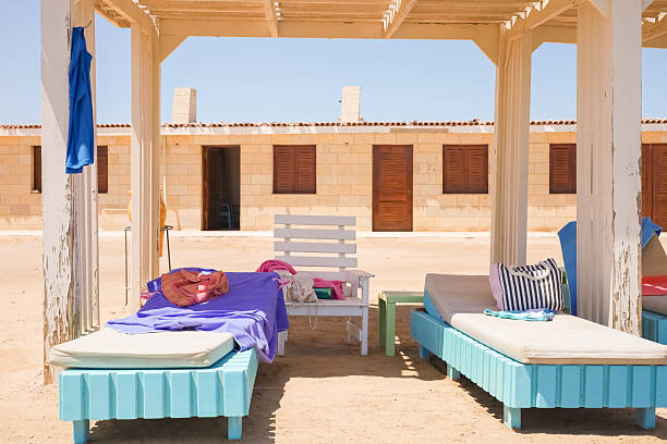 Beautiful English beach huts in a variety of styles and colours, pink, green and striped.